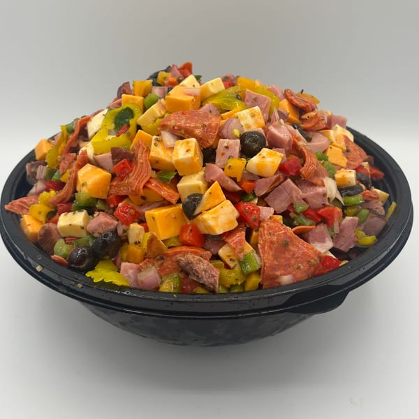 A large black bowl filled with a colorful deli salad featuring cubed meats, cheeses, and vegetables.