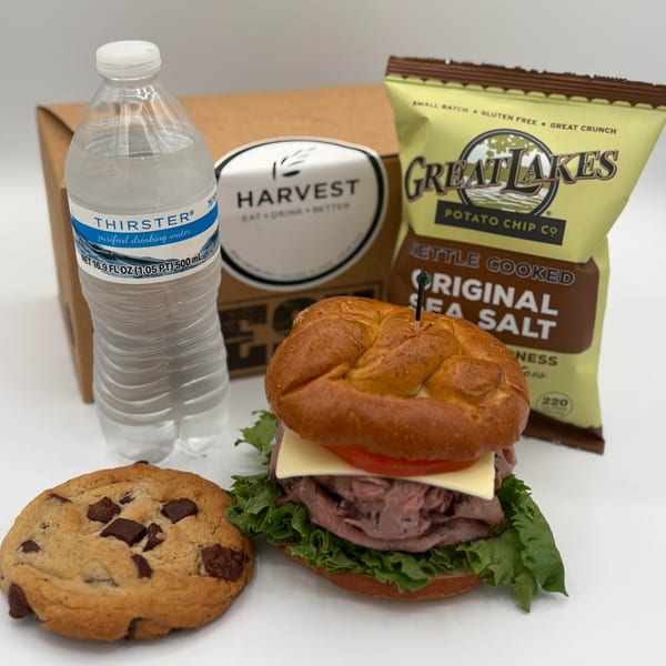 Harvest deli box lunch with a roast beef sandwich, chips, water, and a chocolate chip cookie.